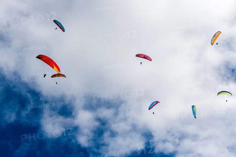 Many paragliders are flying in the air