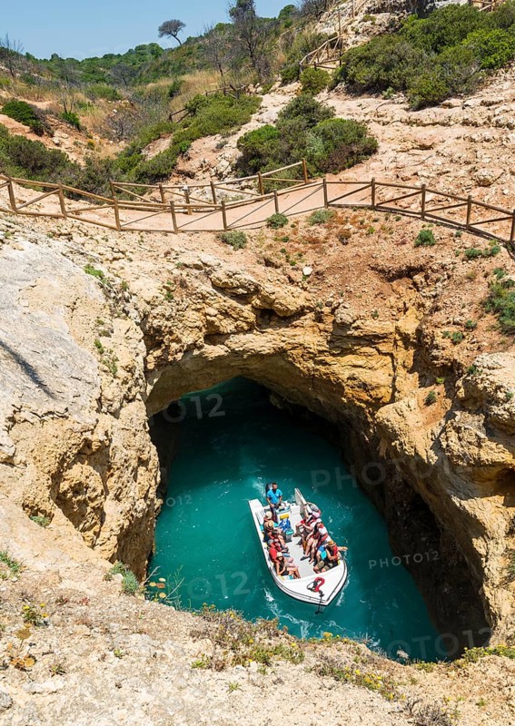 Excursion boat cruises through rock arches and caves