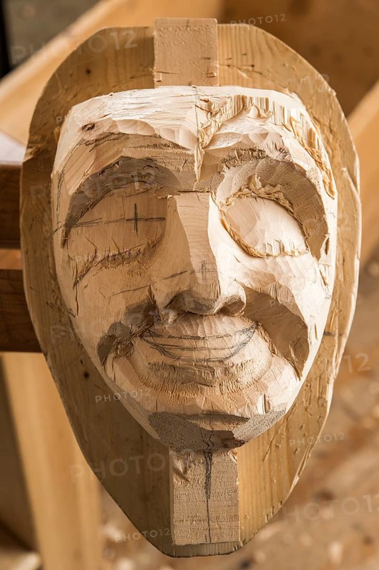 Carved face of an unfinished wooden mask