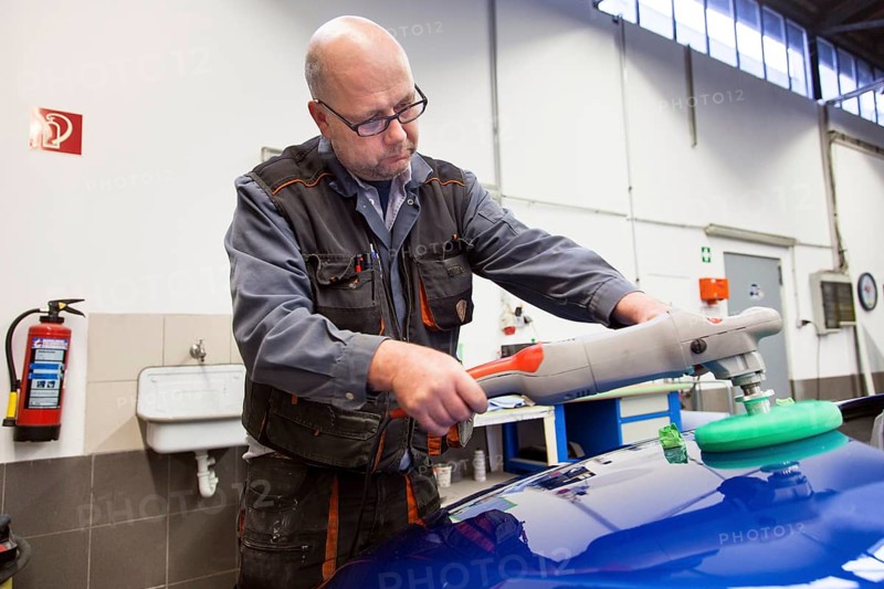 Coachbuilder master with the polishing machine on the car