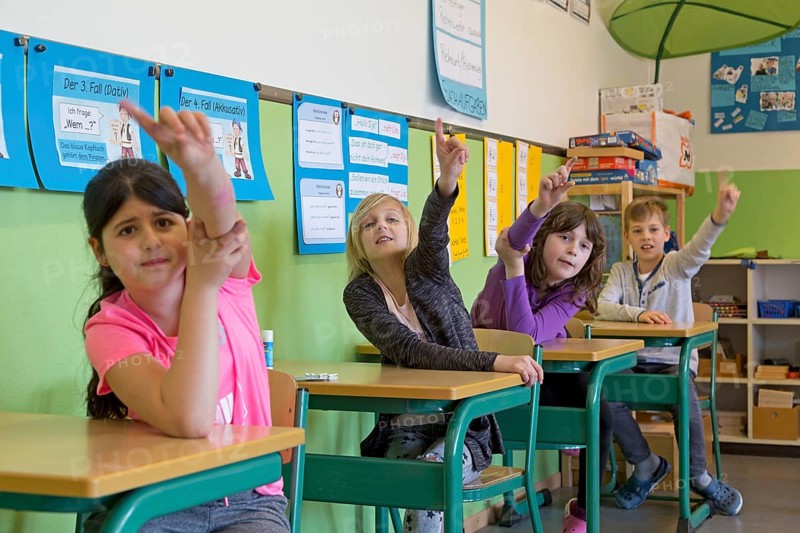 Students raising hand in the classroom