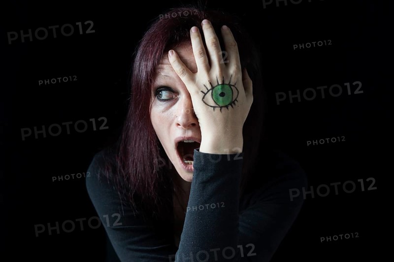 A screaming woman with a painted eye on her hands