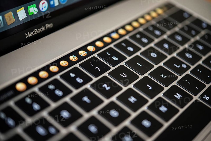 Backlit keyboard and Touch Bar showing emoticons