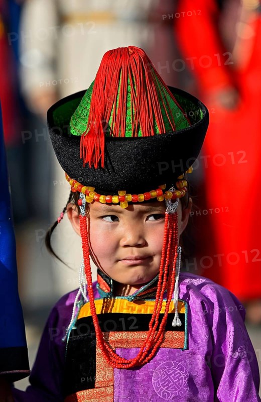 Little girl in traditional Deel clothes and hat with cone-shaped lace