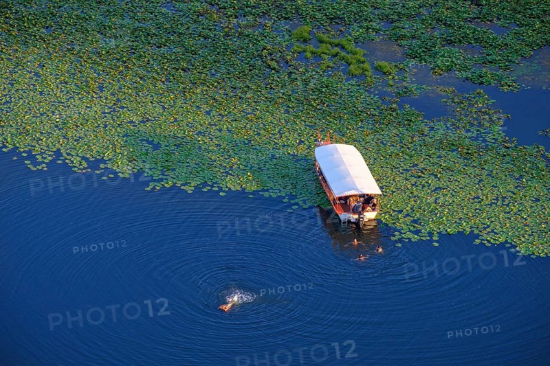 Boat and bathers in the river Rijeka Crnojevica
