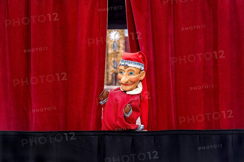 Puppet looking through curtain