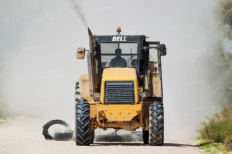 A tractor pulling tyres for grading the parks gravel roads