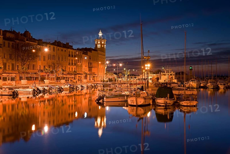 Old city with boats in the harbour at night