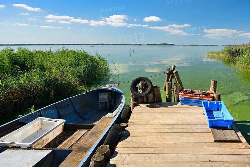 Dock with fishing boat and fish boxes on the Achterwasser