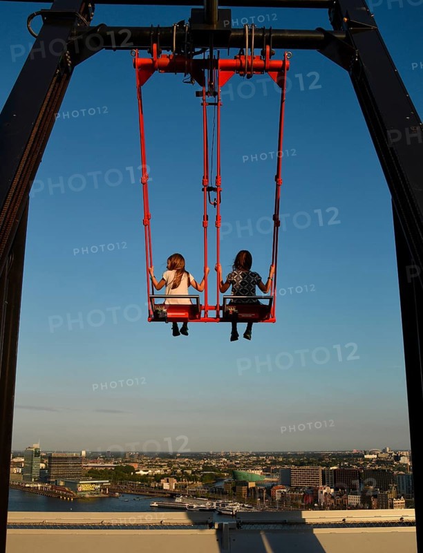 Children sway in the Swing 'Over The Edge high above the rooftops of Amsterdam on the A'DAM LOOKOUT