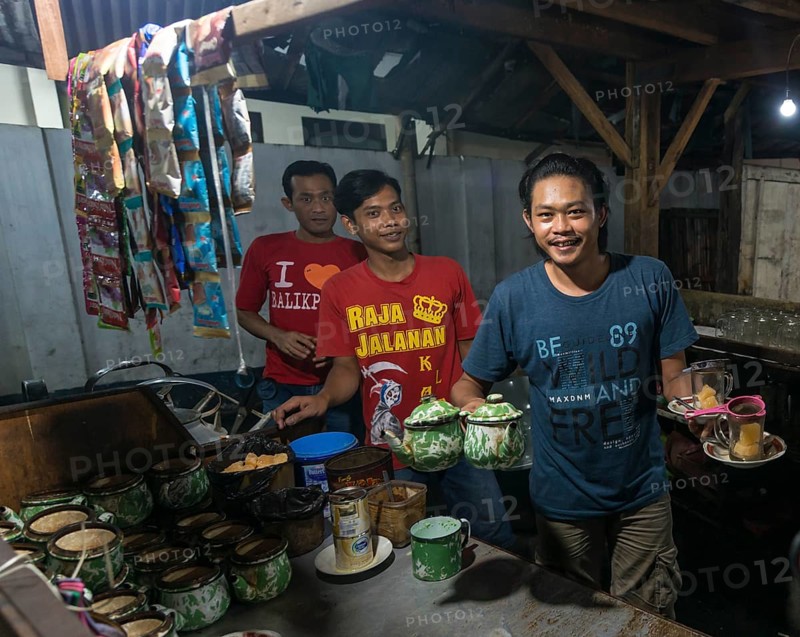 Native waiter offering tea from booth