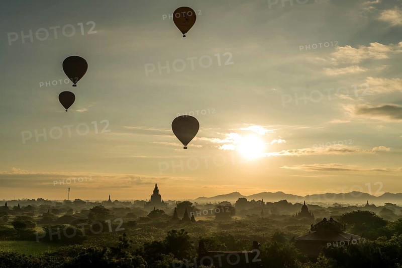 Hot air balloons at sunrise over temples and pagodas