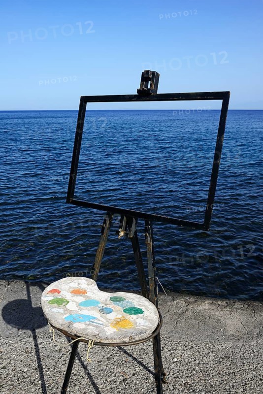 Easel and pallet in front of the sea