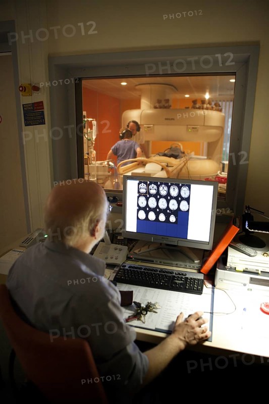 Doctor monitoring computer radiographs of MRI machine