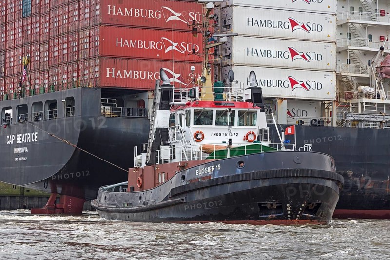 Fully loaded container ship Cap Beatrice being pulled by tugs