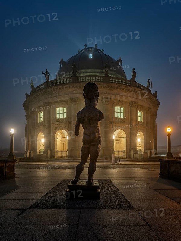 Bodemuseum on the Museum Island with the bronze sculpture Hektor by Markus Lupertz at fog in dusk