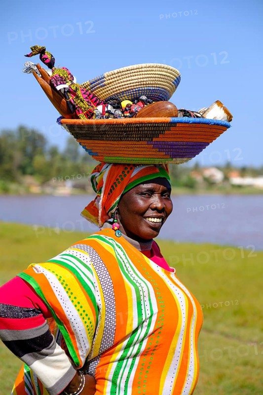 Senegalese woman in colorful dress with goods on her head