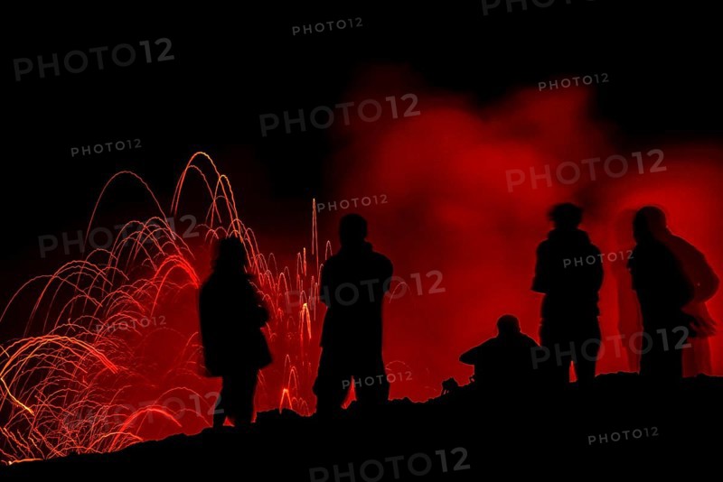 Tourists observe the eruption