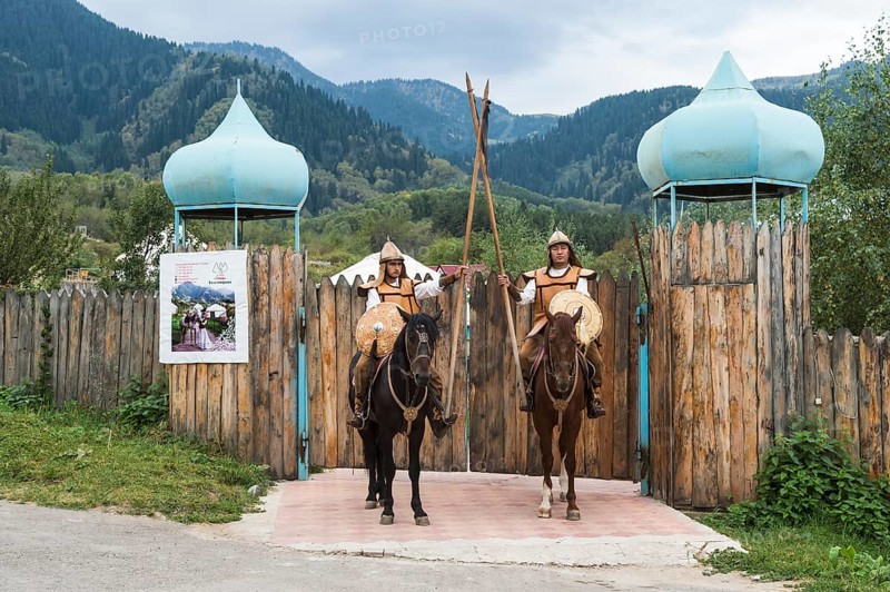 Two men on horseback in front of the entrance to the Kazakh ethnographic village aul Gunny