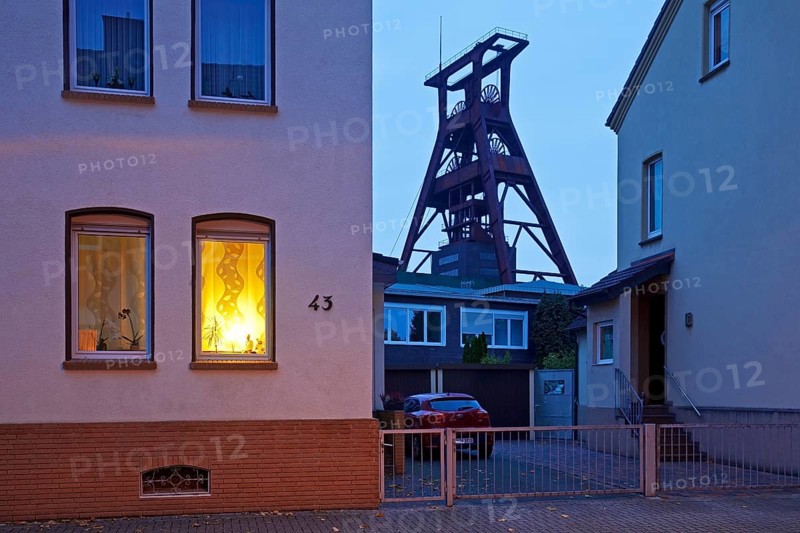 Residential buildings with the winding tower of Pluto colliery at dusk