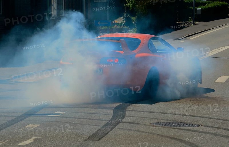 Car burning tire on a street