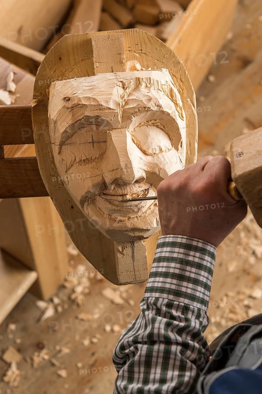 Carving the mouth of a wooden mask using wood carving tools