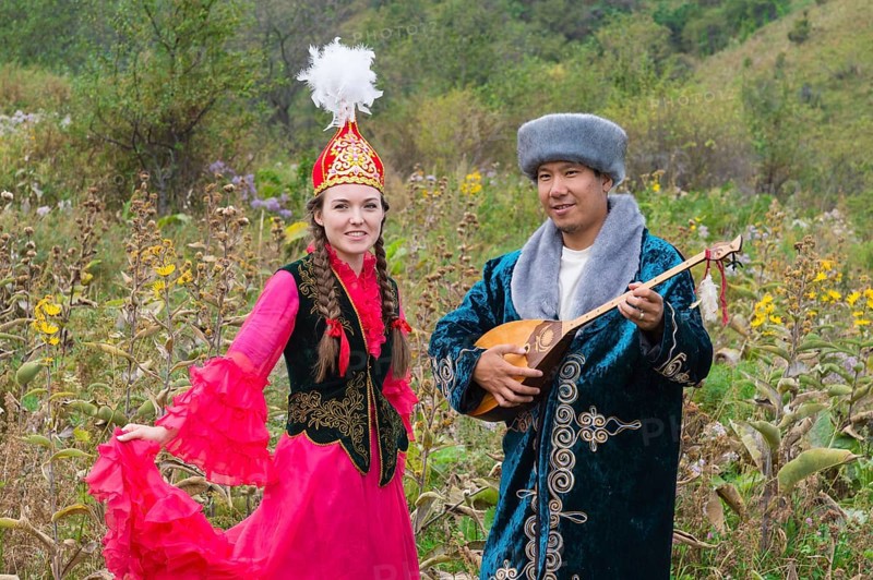 Kazakh man singing and playing the dombra for a woman