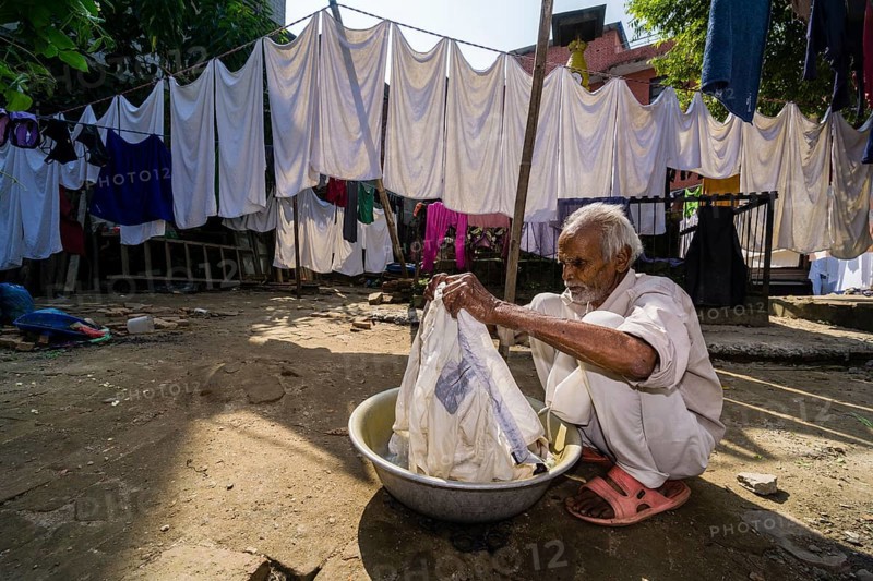 Man doing laundry by hand in courtyard