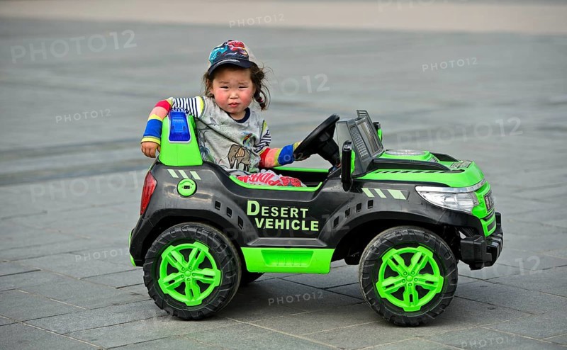 Little girl rides in electric toy car