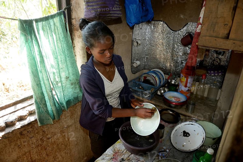 Young woman washes dishes