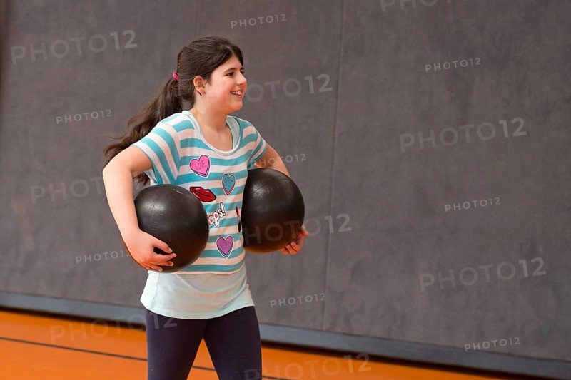 Schoolgirl playing ball in the gym