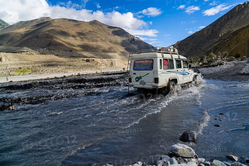 Jeep taxi is crossing a river