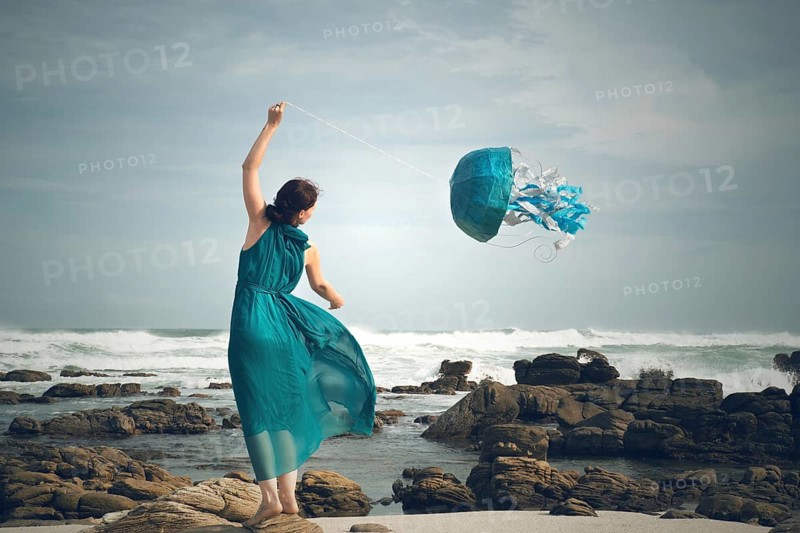 Woman flying a jellyfish kite at the beach