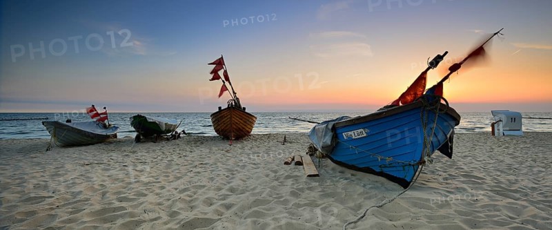 Fishing boats on beach at sunrise