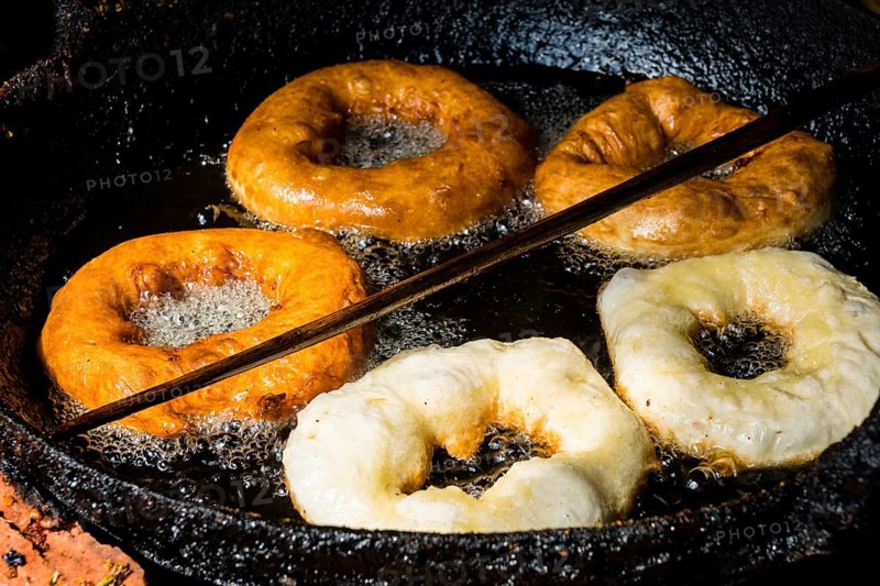 Doughnuts are fried in a pan with hot oil
