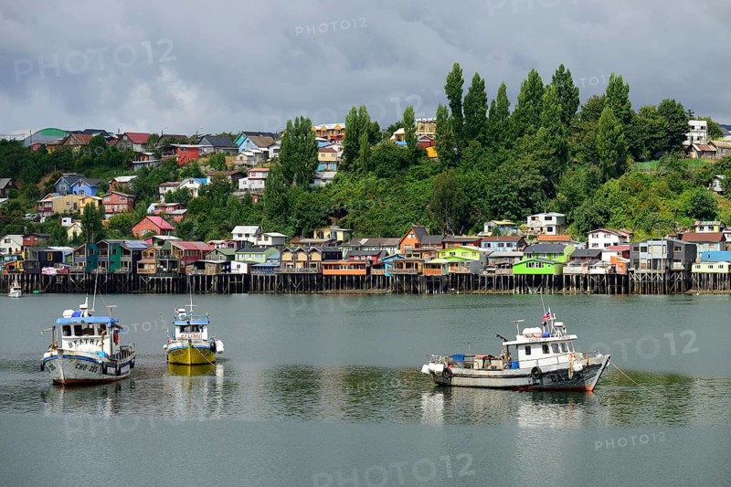 Fishing boats anchoring in front of colorful stilt houses