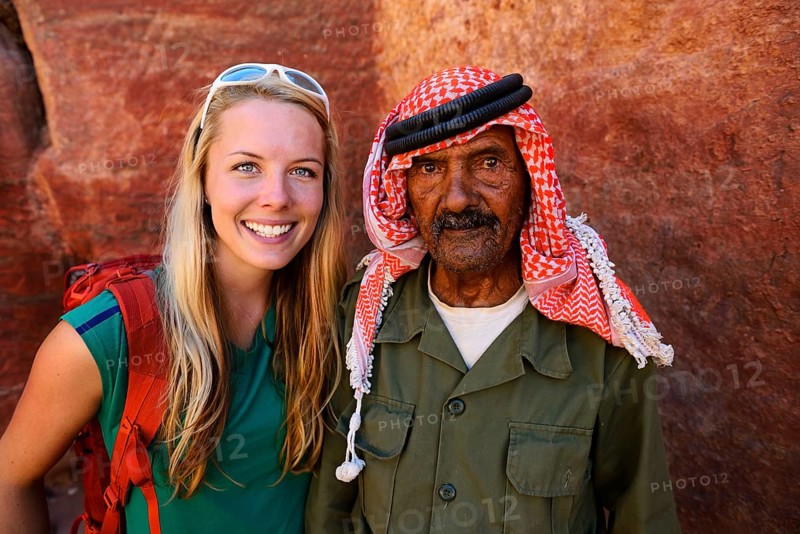 Tourist girl poses with old man