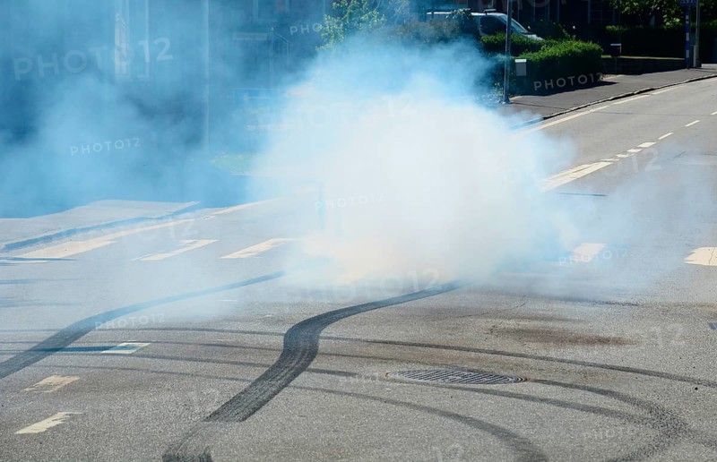 Car burning tire on a street