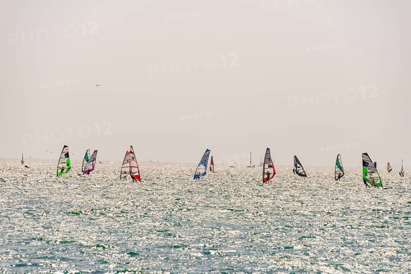 Many windsurfers with colourful sails