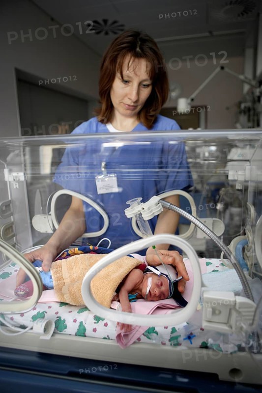 Nurse at incubator with newborn baby
