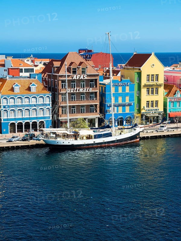 Old sailing ship in front of historic buildings in Dutch-Caribbean colonial style
