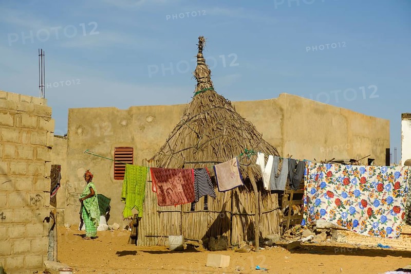 Straw hut next to stone houses