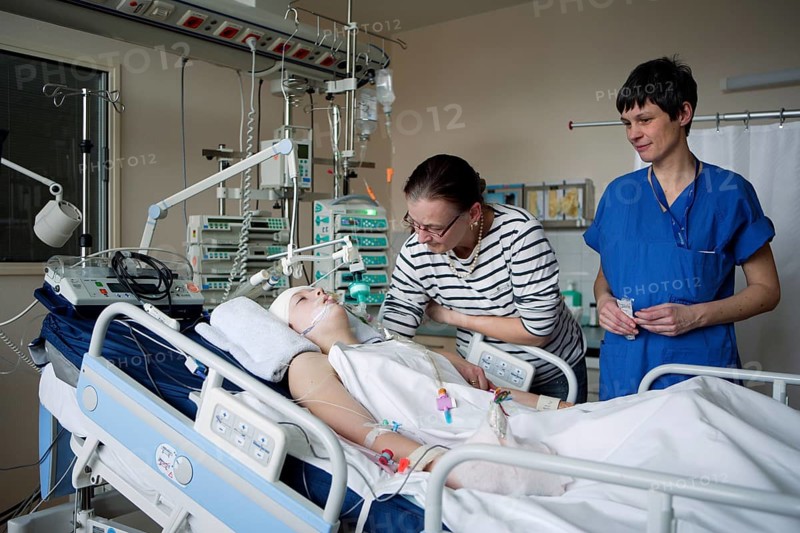 Child with mother and intensive care nurse at the bedside