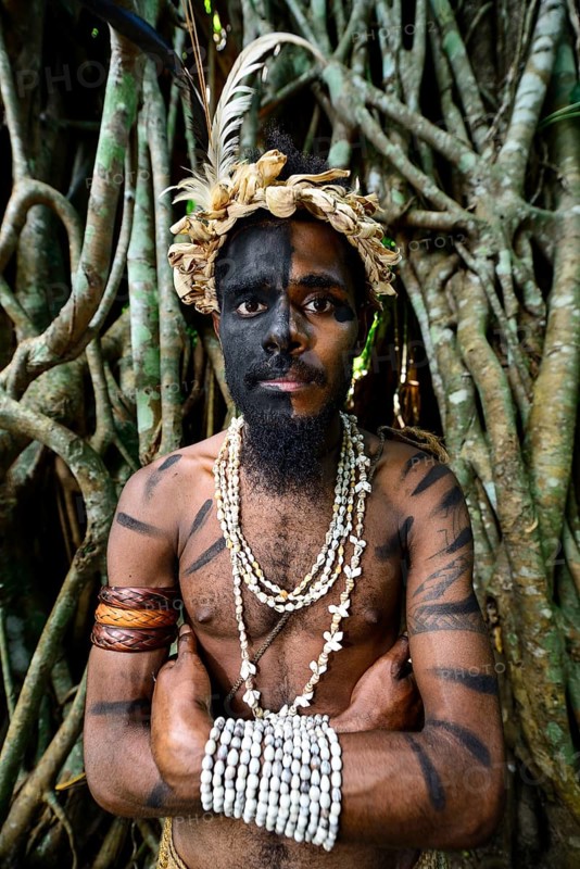 Tribal warrior in front of the roots of the banyan tree