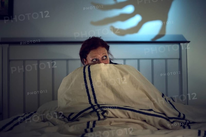 Frightened woman in bed