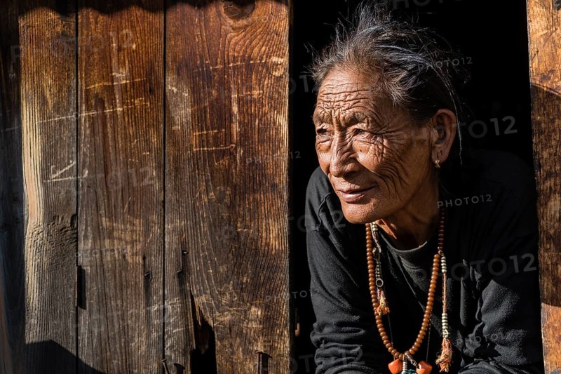 Senior female farmer looking out of a window