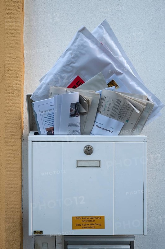 Overfilled mailbox with letters and newspapers