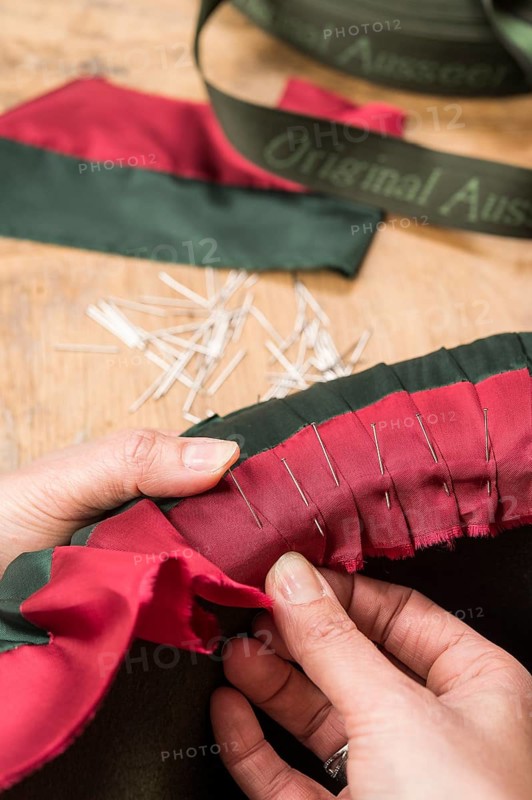 Hands folding and fastening silk ribbon using pins