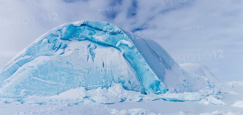 Iceberg seen from frozen fjord