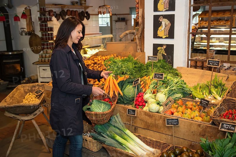 Customer buying carrots at farm shop